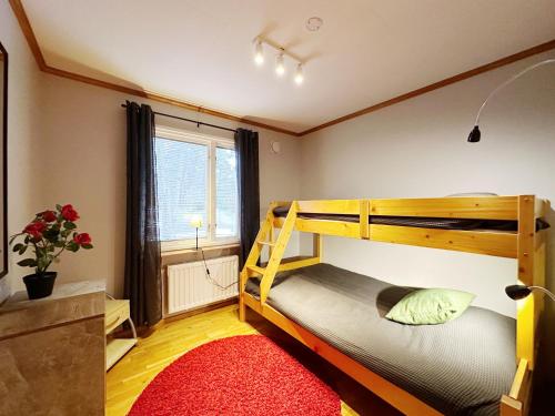 a bedroom with a bunk bed and a red rug at Ystad Holiday Houses in Ystad