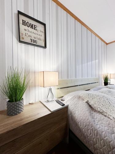a bedroom with a bed and a table with a lamp at Ystad Holiday Houses in Ystad