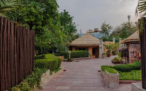 a garden with a fence and a brick walkway at Ajit Bhawan - A Palace Resort in Jodhpur