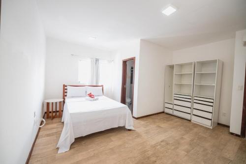 a white bedroom with a bed and a closet at Cobertura exclusiva em ponta negra com vista para o mar in Natal