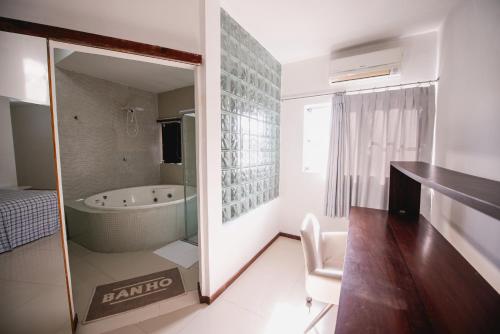 a bathroom with a tub and a chair in a room at Cobertura exclusiva em ponta negra com vista para o mar in Natal