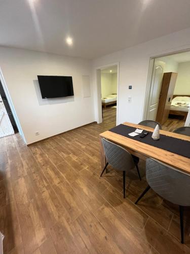 a room with a table and a tv on a wall at Schildetal Apartment's in Vellahn