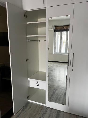 a white closet with glass doors in a room at Metro Connected Homestay with Parkview in Greater Noida