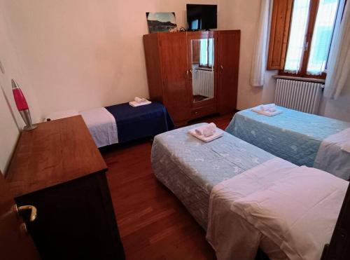 a hotel room with three beds and a table at Cuore di Toscana in Pistoia