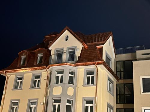 a tall white building with a brown roof at Café Cuore in Sankt Margrethen