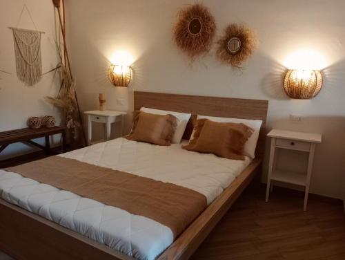 una camera con un grande letto con due lampade a muro di Tratturo dei Greci, biocasa vacanza a Lesina
