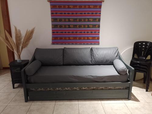 un sofá de cuero negro en una sala de estar con alfombra en Casa de huéspedes con pileta. en Villa Giardino