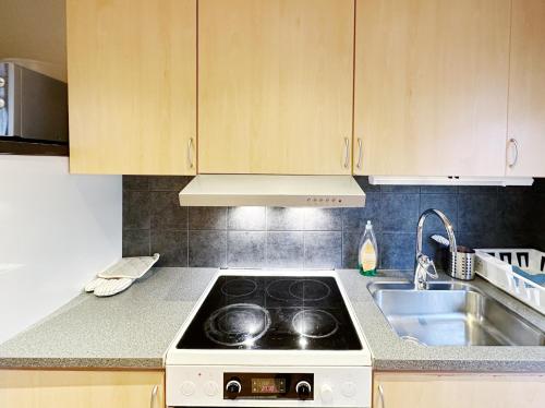a kitchen with a stove top oven next to a sink at Ystad Holiday Houses in Ystad