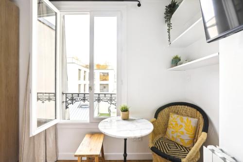 mały pokój ze stołem i oknem w obiekcie Stunning architect studio near Le Marais w Paryżu