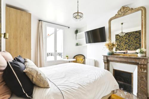 een slaapkamer met een bed, een open haard en een spiegel bij PL2 - Stunning architect studio near Le Marais in Parijs