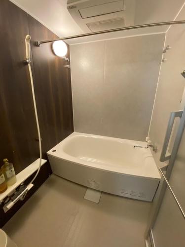 a small bathroom with a white tub and a light at MR TOMO FUJI in Fuji