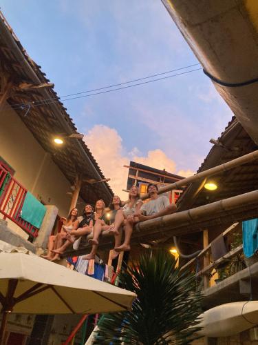um grupo de pessoas sentadas na varanda de um edifício em La Boheme Bajo em Labuan Bajo