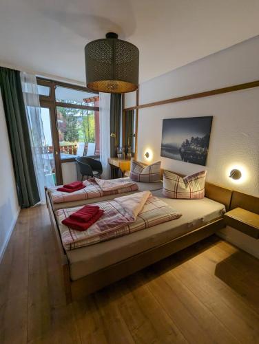 a bedroom with two beds and a large window at Ferienwohnung Schwarzwaldlust in Schluchsee