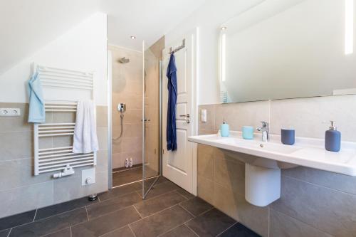 a bathroom with a sink and a shower at Bornhaus für 7 Personen in Born