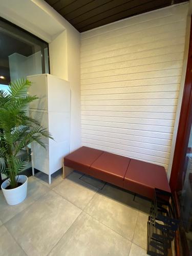 a red bench sitting in front of a wall at MR TOMO FUJI in Fuji