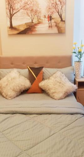 a bed with two pillows on top of it at Unit 3J Signature Suites, Lafayette Megaworld in Iloilo City