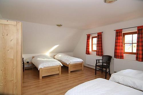 una stanza con tre letti e una sedia di CHALUPA Honzík - VILLA Vrchlabí a Vrchlabí
