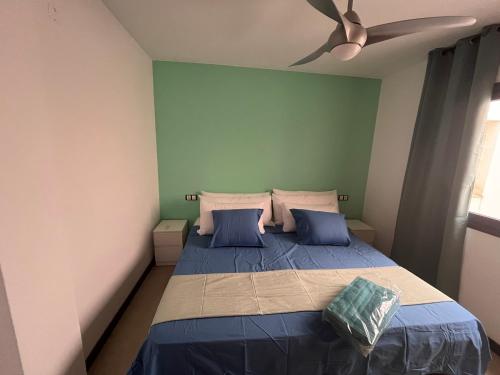 コティージョにあるCasa Teri - La Conchaのベッドルーム1室(青いシーツと天井ファン付きのベッド1台付)