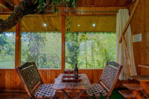 a dining room with a table and two chairs at Himalayan Abode Tree House in Sainj