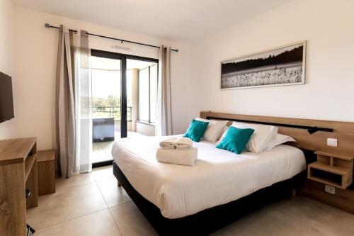 une chambre avec un grand lit avec des oreillers bleus dans l'établissement Proche centre ville et commodités, appt 4/6 pers, à Porto-Vecchio