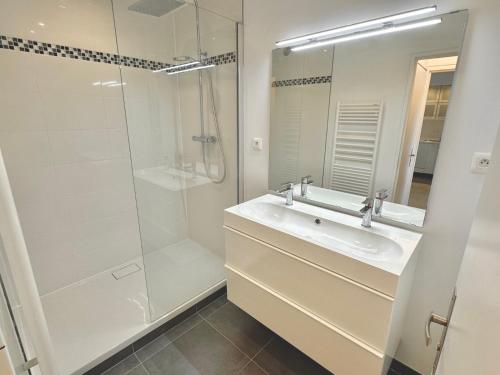 une salle de bain blanche avec un lavabo et une douche dans l'établissement Moderne T2, bord de mer, Parking & Wifi gratuit, à Villers-sur-Mer