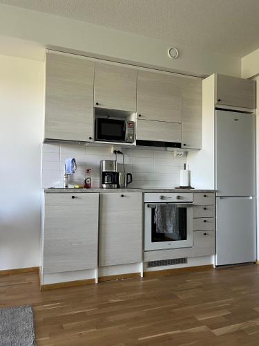 eine Küche mit Küchengeräten aus Edelstahl und weißen Schränken in der Unterkunft Helsinki Espoo Bright apartment /w big balcony close to Aalto University and metro in Espoo