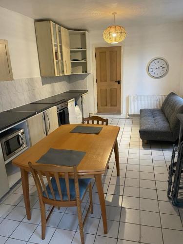 a kitchen with a wooden table and a couch at Colchester house in London