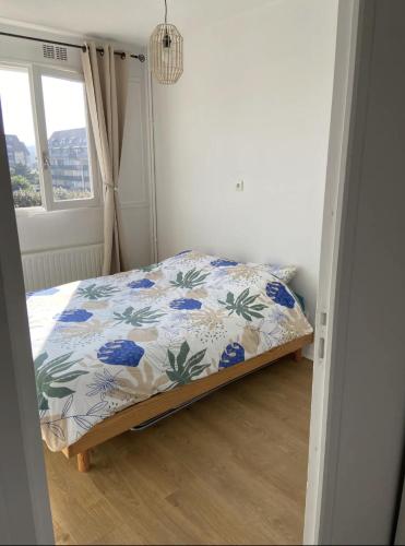 une chambre avec un lit avec un couvre-lit fleuri dans l'établissement Le petit Villers, à Villers-sur-Mer