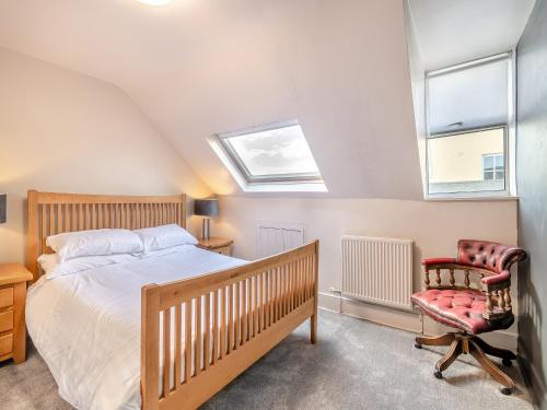 a bedroom with a bed and a chair at Beaufort Apartment in Tenby