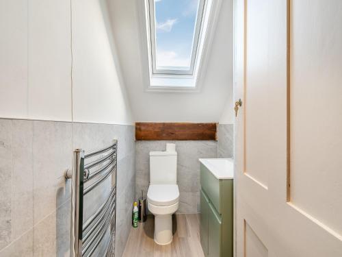 a bathroom with a toilet and a window at Beaufort Apartment in Tenby