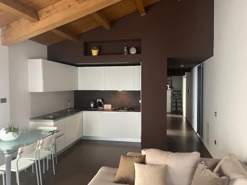eine Küche und ein Wohnzimmer mit einem Sofa und einem Tisch in der Unterkunft Elegante torretta in centro in Faenza