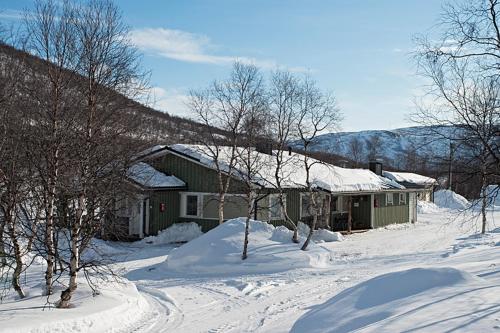 a house is covered in snow in a snowy yard at Holiday Village Valle in Utsjoki