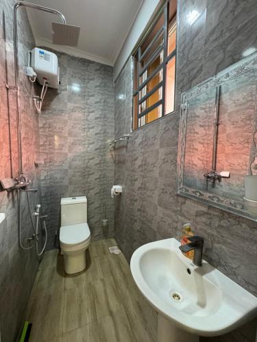 uma casa de banho com um lavatório e um WC em Suji House em Dodoma