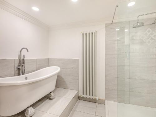 y baño blanco con bañera y ducha. en Iris Apartment - Uk45966, en Yarm
