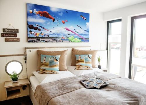 a bedroom with a large bed with a large painting on the wall at Perlekieker 1 in Büsum