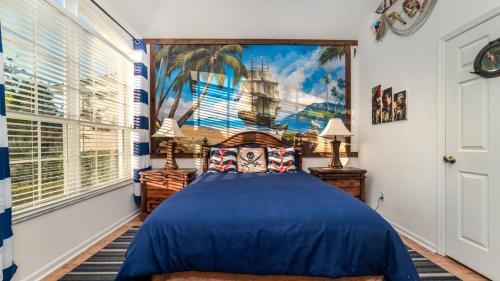 1 dormitorio con cama azul y ventana grande en 6 BR Vacation Home for 12 Guests, en Kissimmee