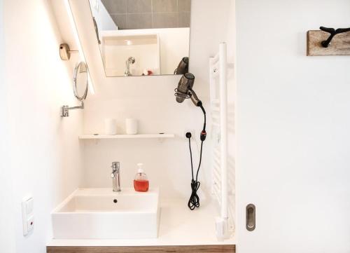 a small bathroom with a sink and a microscope at Achtern Diek in Büsum