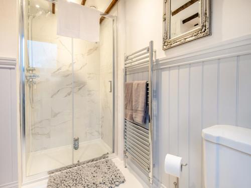 ein Bad mit einer Dusche und einer Glastür in der Unterkunft Prince Of Wales Lodge in Caston