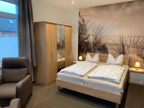 ein Schlafzimmer mit einem Bett und einem Stuhl in der Unterkunft Pension Haus Beckmann in Borkum
