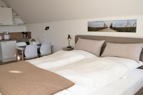 a large white bed in a room with a kitchen at Sandbank in Büsum