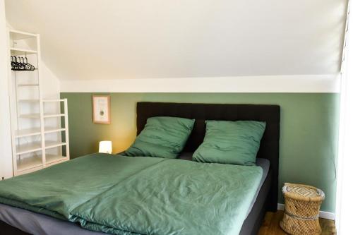 een slaapkamer met een bed met groene lakens bij Haus Deichkind in Büsum