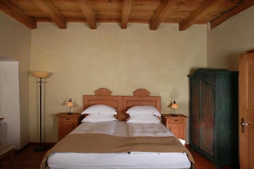 a bedroom with a large bed and two night stands at Fronius Boutique Residence in Sighişoara
