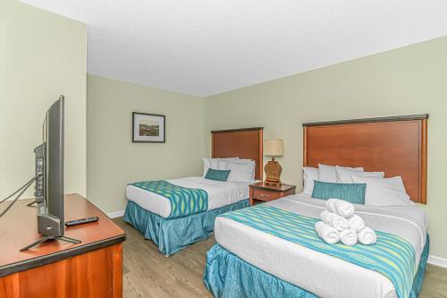 ein Hotelzimmer mit 2 Betten und einem Flachbild-TV in der Unterkunft Sandy Beach 1612 in Myrtle Beach