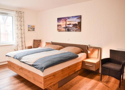 a bedroom with a bed and a chair at Appartement Abendsonne in Büsum