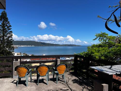 una mesa y sillas en un balcón con vistas al océano en Residencial Bombinhas Vista Mar, en Bombinhas