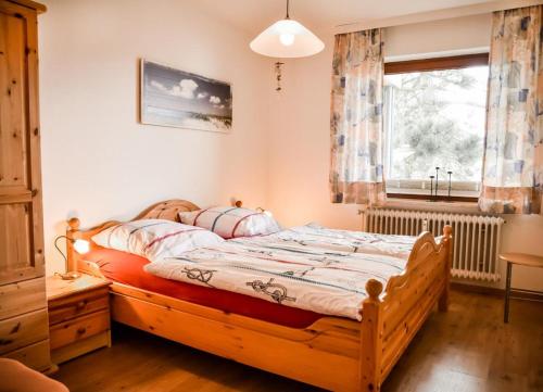 ein Schlafzimmer mit einem Holzbett und einem Fenster in der Unterkunft Muschelbank in Büsum