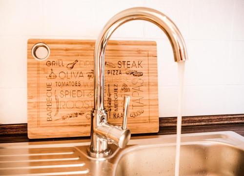 a kitchen sink with a faucet and a wooden cutting board at Muschel24 in Büsum