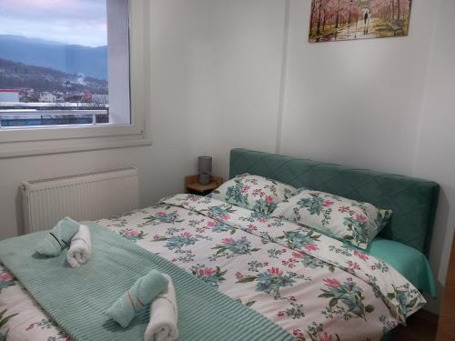 a bedroom with a bed with socks and a window at Stan na dan - Apartman Blue Moon in Lukavica