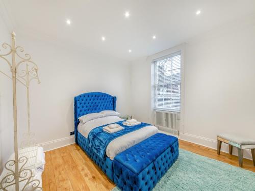 a blue bed in a white room with a window at Blossom Apartment - Uk45970 in Yarm