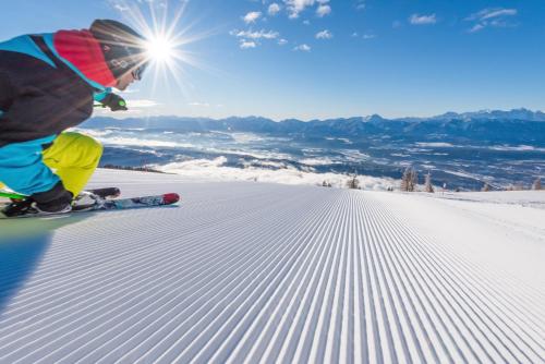 a young child is skiing down a snow covered slope at Gerlitzen-Apartments in Kanzelhöhe